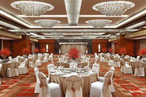 a banquet hall with tables and chairs and chandeliers at Sheraton Wenzhou Hotel in Wenzhou