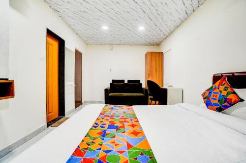 a bedroom with a bed with a colorful bedspread at Hotel Omkar & Lodging - phoenix market city in Pune