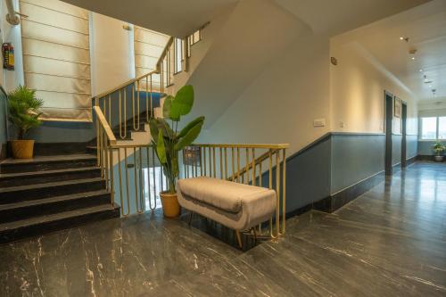 a room with a staircase with a chair and a plant at Hotel Lake Metro in Udaipur