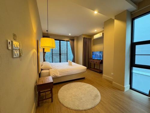 a bedroom with a bed and a table and a window at Monte Villa Chiang Mai in Ban Nong Chaeng