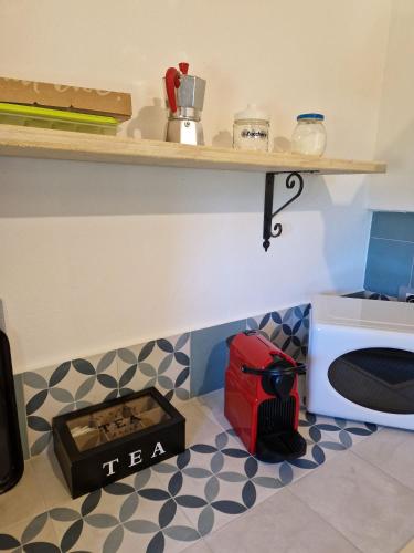 a kitchen with a microwave and a box on the floor at Borgo Melograno in Chiusi