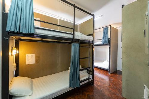 a room with three bunk beds in a building at KAYAN Hostel in Chiang Mai