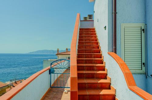 een trap op een gebouw naast het water bij Mermaid in Cala Gonone