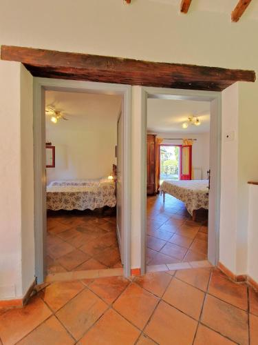a bedroom with two beds in a room with a tile floor at Borgo Melograno in Chiusi
