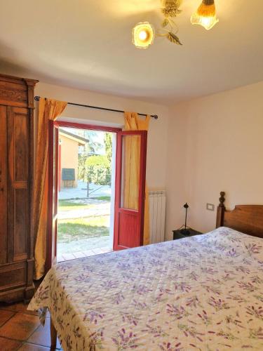 a bedroom with a bed and a sliding glass door at Borgo Melograno in Chiusi