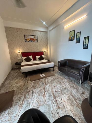 a bedroom with a bed and a couch in a room at Hotel Sangam View in Prayagraj