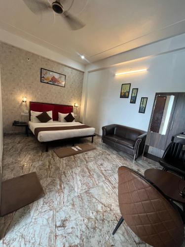 a hotel room with a bed and a couch and a chair at Hotel Sangam View in Prayagraj
