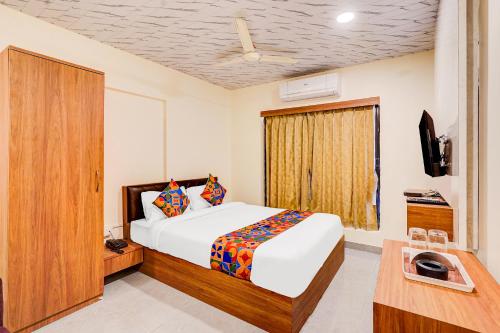 a bedroom with a bed and a television in a room at Hotel Omkar & Lodging - phoenix market city in Pune