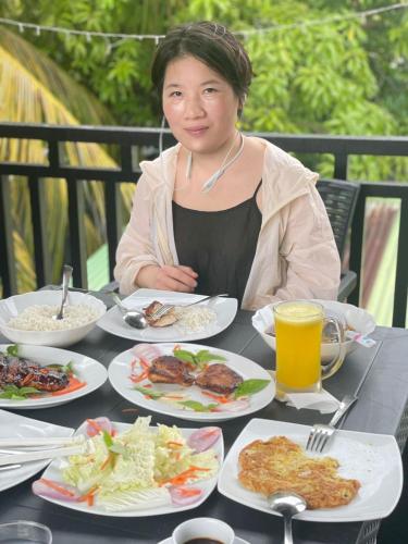 a woman sitting at a table with plates of food at Rihiveli inn 