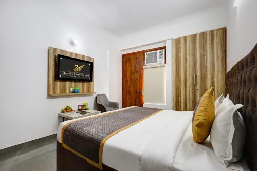 a hotel room with a bed and a tv at FabHotel La Corporate Suite in Noida