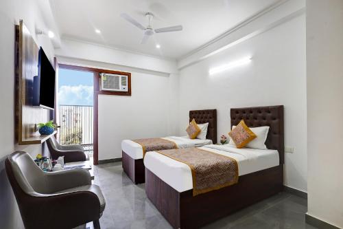 a hotel room with two beds and a television at FabHotel La Corporate Suite in Noida