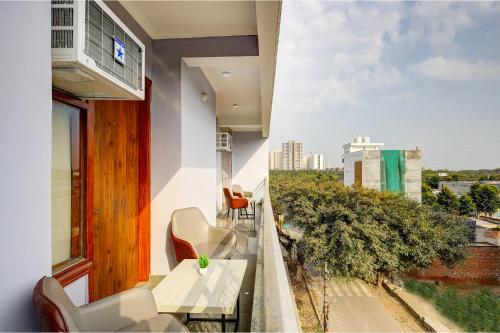 a balcony with chairs and tables and a view of a city at FabHotel La Corporate Suite in Noida