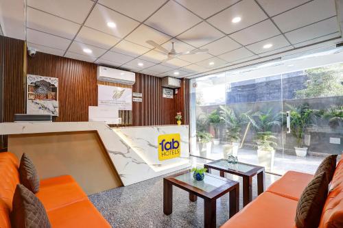 an office with orange furniture and a large window at FabHotel La Corporate Suite in Noida