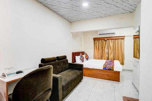a living room with a couch and a bed at Hotel Omkar & Lodging - phoenix market city in Pune