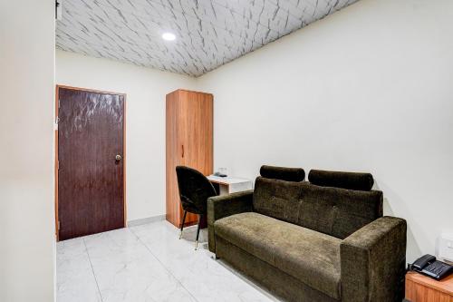 a living room with a couch and a desk at Hotel Omkar & Lodging - phoenix market city in Pune