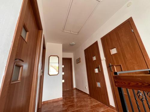 a hallway with two wooden doors and a staircase at Pokoje gościnne JAVKA w Jantarze in Jantar