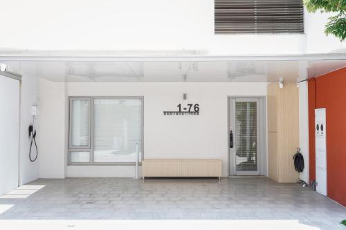 a white building with a sign on the wall at 微風徐徐 Breezy Stay & 漫步阿里 Annie's Home in Zhongpu