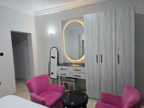 a room with two pink chairs and a mirror at شركة فؤاد علي العزي للشقق المخدومة in Taif