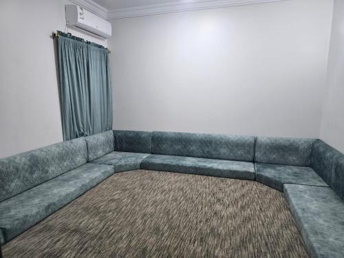 a couch in a living room with a window at شركة فؤاد علي العزي للشقق المخدومة in Taif