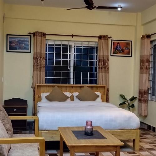 a bedroom with a bed and a table and a window at Northern Suite Home in Pokhara