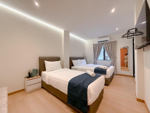 a bedroom with two beds and a television in it at Resandau Stay Ipoh - Nearby Ipoh Town - Private Car Park and Lift - Whole unit & Coliving in Ipoh