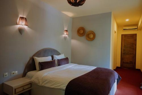 a bedroom with a bed and two lights on the wall at Nekresi Estate in Kvareli