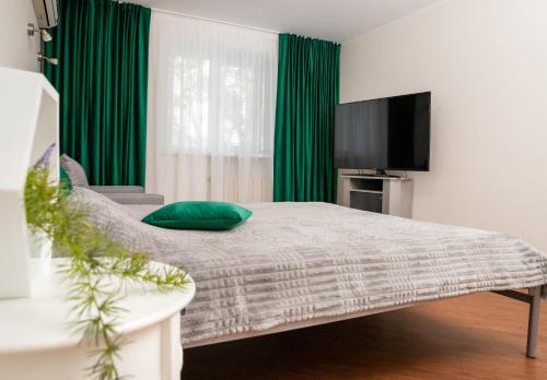 a living room with a bed and a flat screen tv at Lotos for You Apartments in Mykolaiv