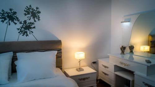 a bedroom with a bed with a lamp and a dresser at Luxury Budva Center Apartments in Budva