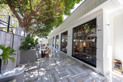 an outdoor patio with large windows and trees at Chamada Girne Hotel Spa and Casino in Kérynia