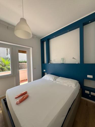 Un dormitorio con una gran cama blanca con una pared azul. en Tiber Domus Fiumicino - Apt 2, en Fiumicino