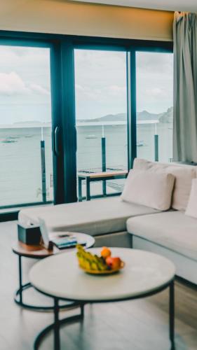 a living room with a table with a bowl of fruit on it at H Hotel El Nido - Vegan Friendly Hotel Managed by H Hospitality Group in El Nido