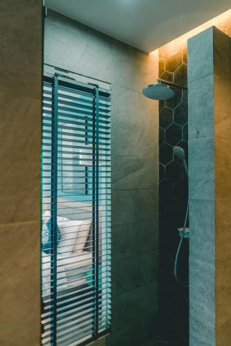 a bathroom with a shower with a glass door at H Hotel El Nido - Vegan Friendly Hotel Managed by H Hospitality Group in El Nido