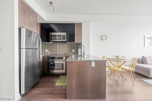 a kitchen with stainless steel appliances and a couch at Cozy 1 Bedroom Dunfield Ave in Toronto