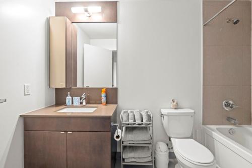 a bathroom with a sink and a toilet and a mirror at Cozy 1 Bedroom Dunfield Ave in Toronto