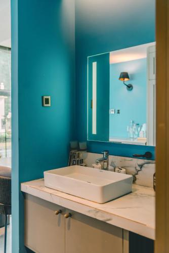 a bathroom with a white sink and a mirror at H Hotel El Nido - Vegan Friendly Hotel Managed by H Hospitality Group in El Nido