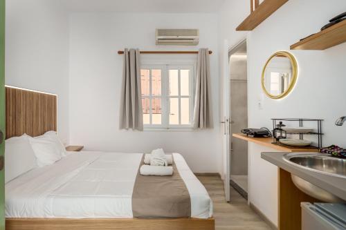 a white bedroom with a bed and a sink at Vincenzo Harmony II- Rethymno old town in Rethymno Town