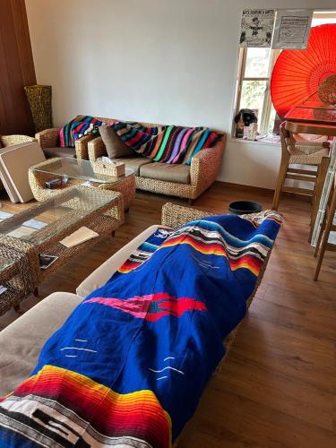 a living room with a colorful blanket on the floor at Leo in Kō-jima