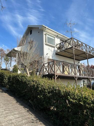 a house with a balcony on the side of it at Leo in Kō-jima