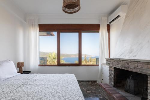 a bedroom with a fireplace and a large window at MUSES CHALKIDIKI #Skgbnb in Mesochórion