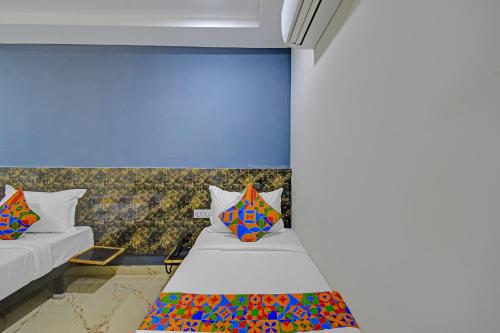 a room with two beds and a blue wall at FabHotel Rio - Nr Ramoji Filmcity, LB Nagar in Hyderabad