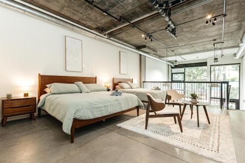 ein Schlafzimmer mit zwei Betten und einem Tisch und Stühlen in der Unterkunft Palm & Vine MODERN COZY LOFT in HOLLYWOOD, FREE Parking in Los Angeles