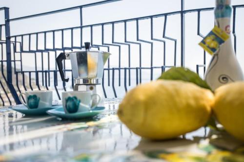 a juicer and two oranges on a table with two cups at Casa Le Marinelle Amalfi Coast in Vietri sul Mare