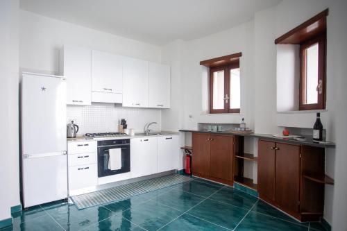 a kitchen with white cabinets and a blue tile floor at Casa Le Marinelle Amalfi Coast in Vietri sul Mare