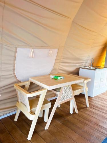 a wooden table and chairs in a tent at Reef Resort - Pearl Farm Resort View B5 in Kaputian