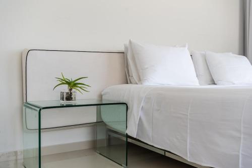 a bed with a glass table with a plant on it at Villa Belle Azure in Dhërmi