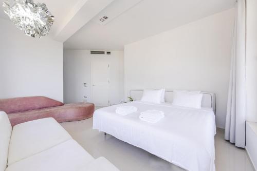 a white bedroom with a large bed and a couch at Villa Belle Azure in Dhërmi