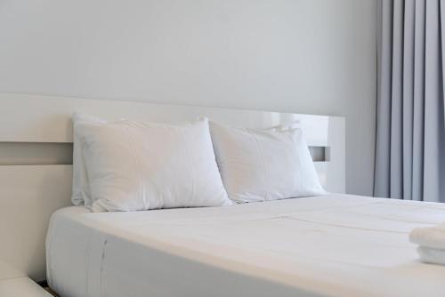 a white bed with white pillows in a bedroom at Villa Belle Azure in Dhërmi