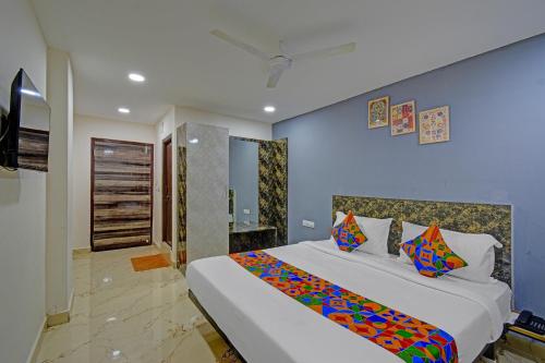 a bedroom with a large white bed with colorful pillows at FabHotel Rio - Nr Ramoji Filmcity, LB Nagar in Hyderabad