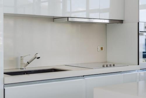 a kitchen with white cabinets and a sink at Villa Belle Azure in Dhërmi