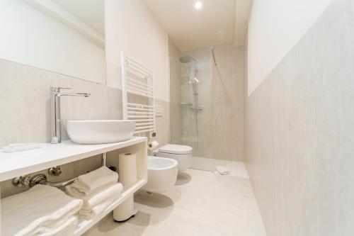 a white bathroom with a sink and a toilet at Al Torrione in Collecchio